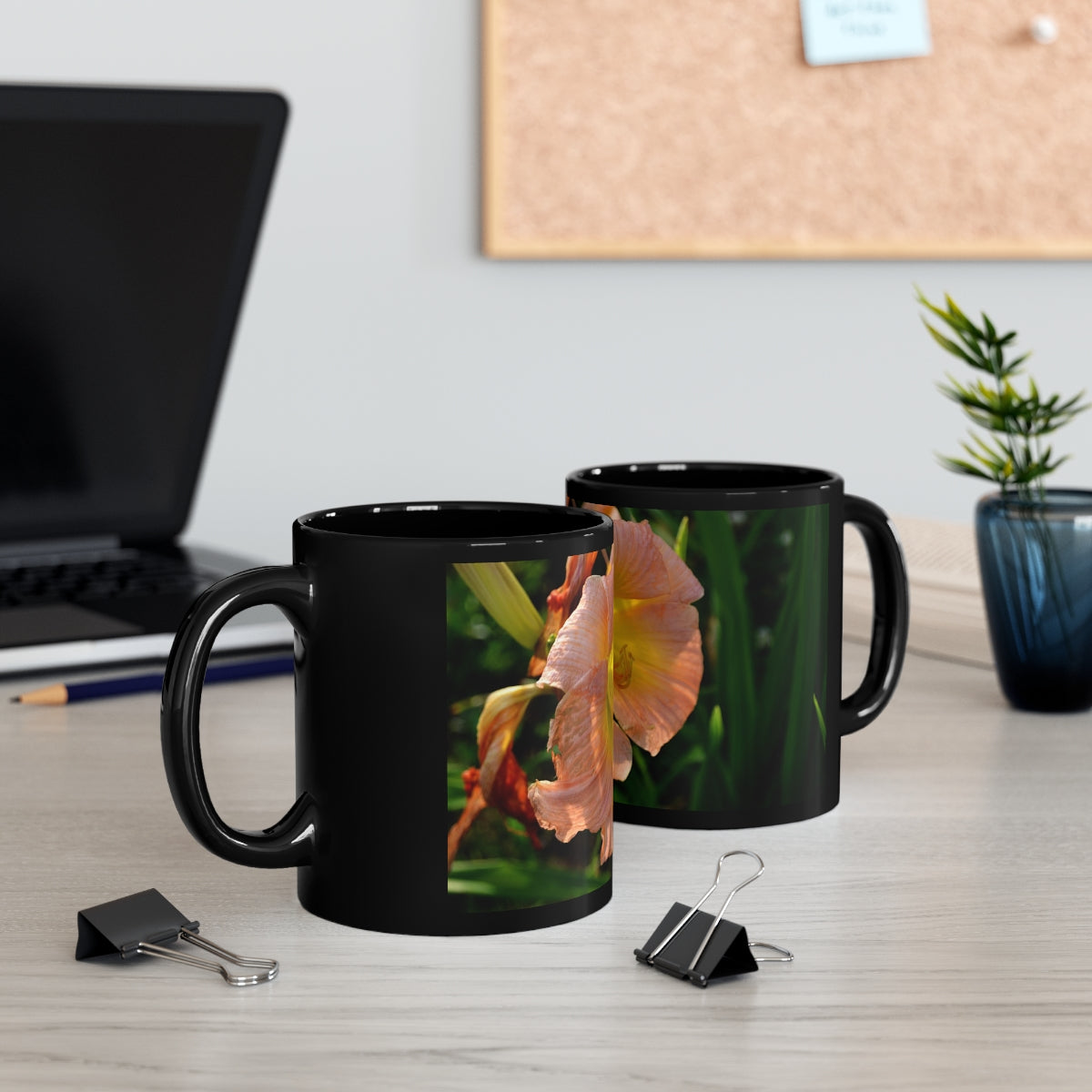 Peach and yellow flower design on a black ceramic mug, perfect for coffee or tea.