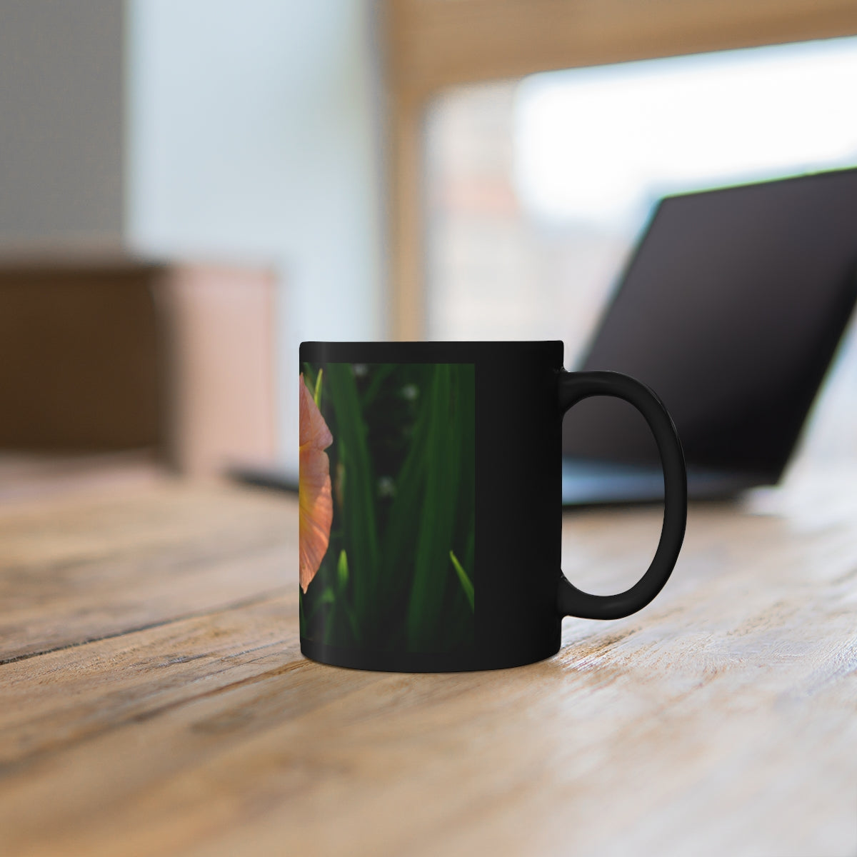 Peach and yellow flower design on a black ceramic mug, perfect for coffee or tea.