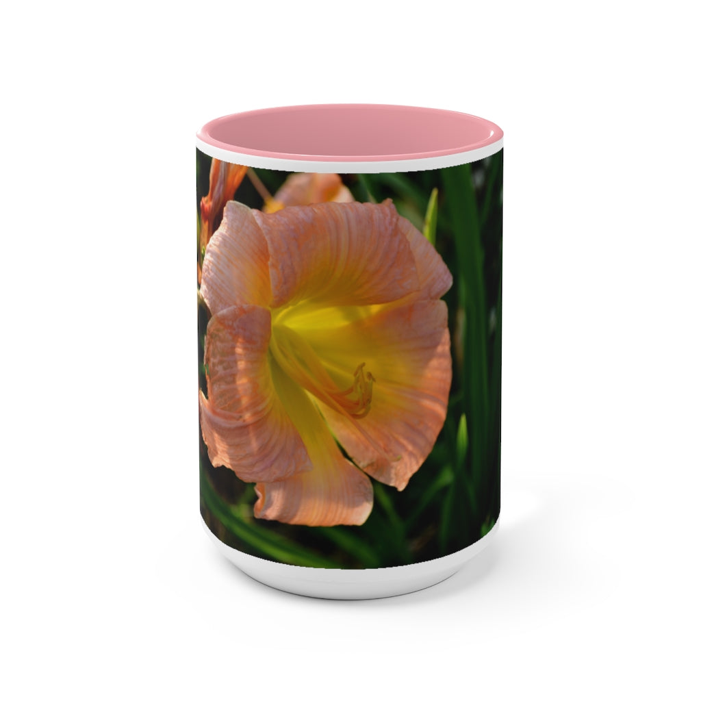 A ceramic mug featuring a peach and yellow flower design with a white exterior and colored interior, showcasing its vibrant colors and comfortable C-handle.