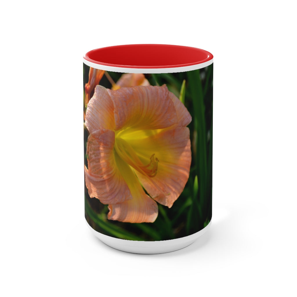 A ceramic mug featuring a peach and yellow flower design with a white exterior and colored interior, showcasing its vibrant colors and comfortable C-handle.