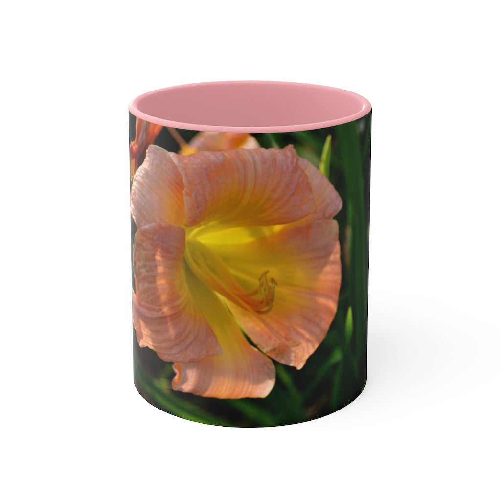 A ceramic mug featuring a peach and yellow flower design with a white exterior and colored interior, showcasing its vibrant colors and comfortable C-handle.