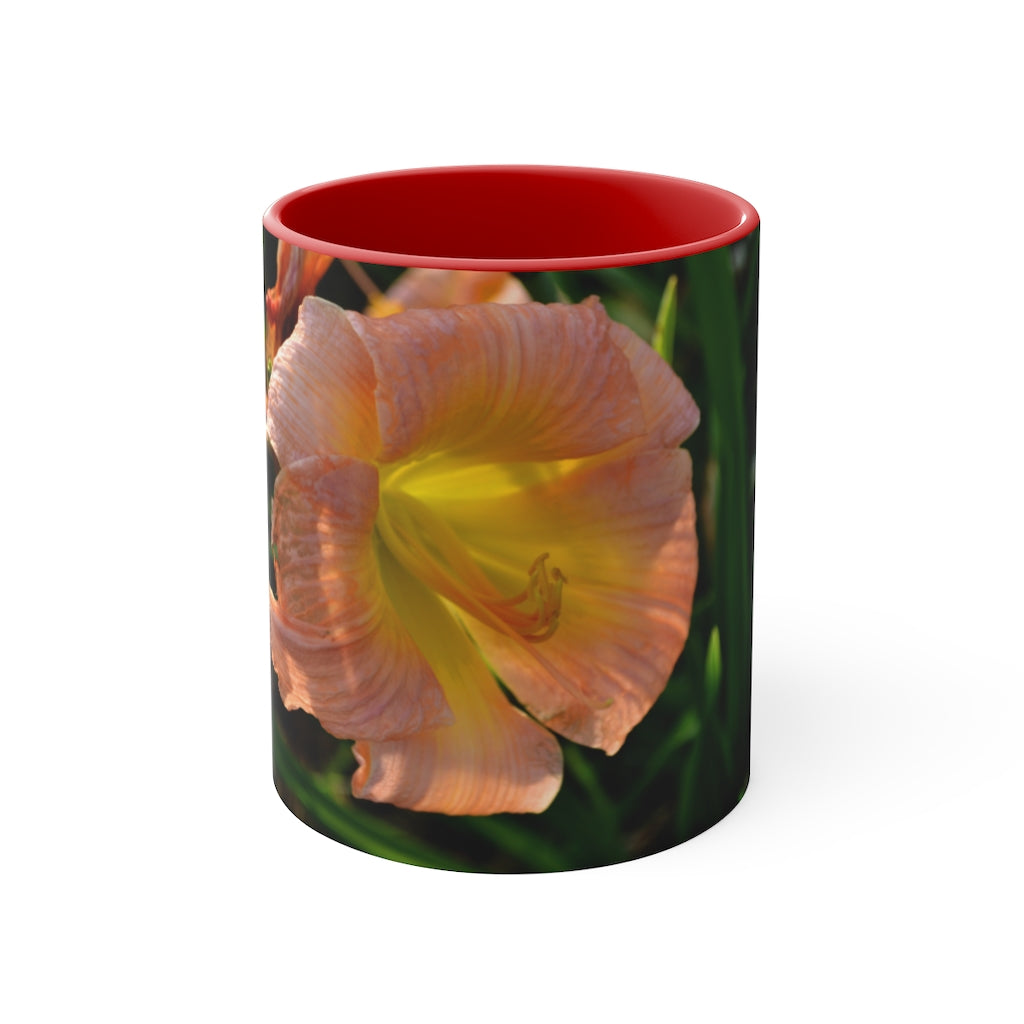 A ceramic mug featuring a peach and yellow flower design with a white exterior and colored interior, showcasing its vibrant colors and comfortable C-handle.