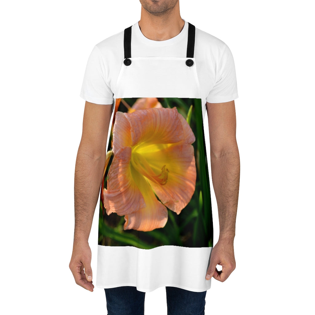 Peach and yellow flower apron with black detachable twill straps, perfect for cooking.