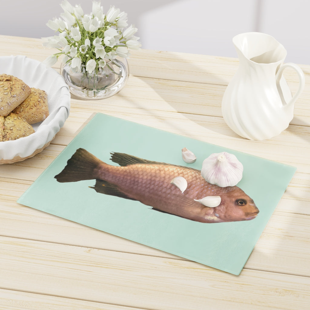 A stylish Peach Fish Cutting Board made of tempered glass, featuring a vibrant peach fish design and four rubber dots for stability.