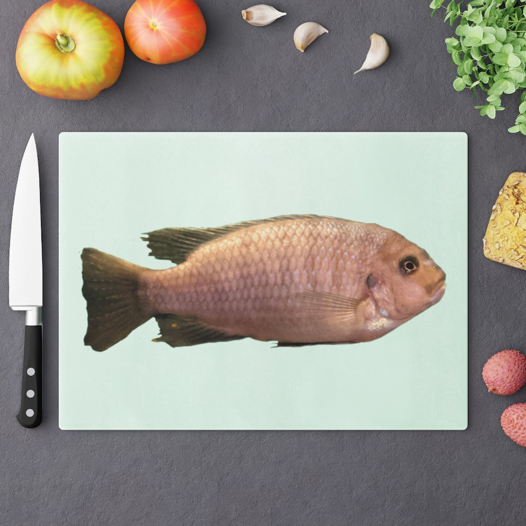 A stylish Peach Fish Cutting Board made of tempered glass, featuring a vibrant peach fish design and four rubber dots for stability.