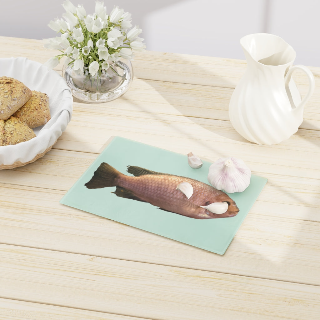 A stylish Peach Fish Cutting Board made of tempered glass, featuring a vibrant peach fish design and four rubber dots for stability.