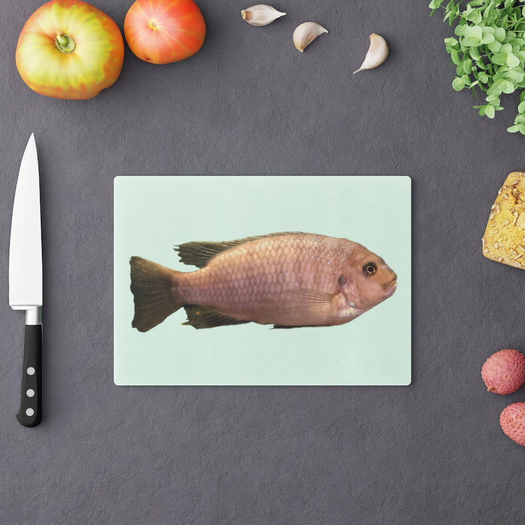 A stylish Peach Fish Cutting Board made of tempered glass, featuring a vibrant peach fish design and four rubber dots for stability.