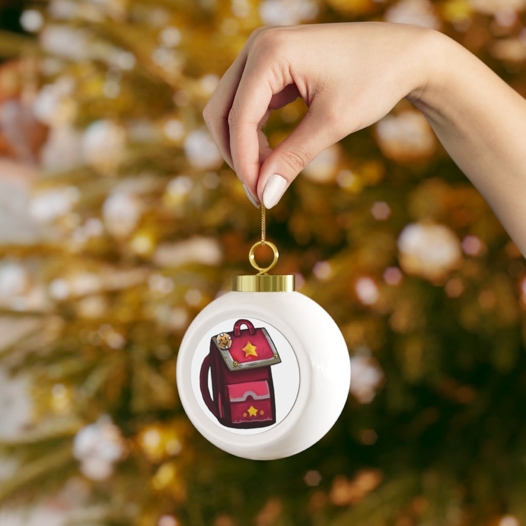 A beautiful pink ceramic Christmas ball ornament with a glossy finish, featuring a gold ribbon for hanging and a vintage design.