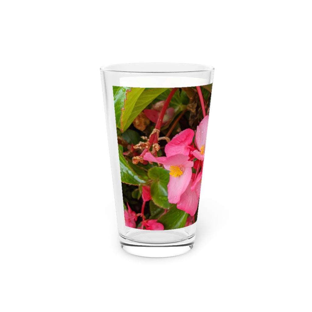 A clear 16oz pint glass featuring a pink flower design, perfect for personalized beverages.