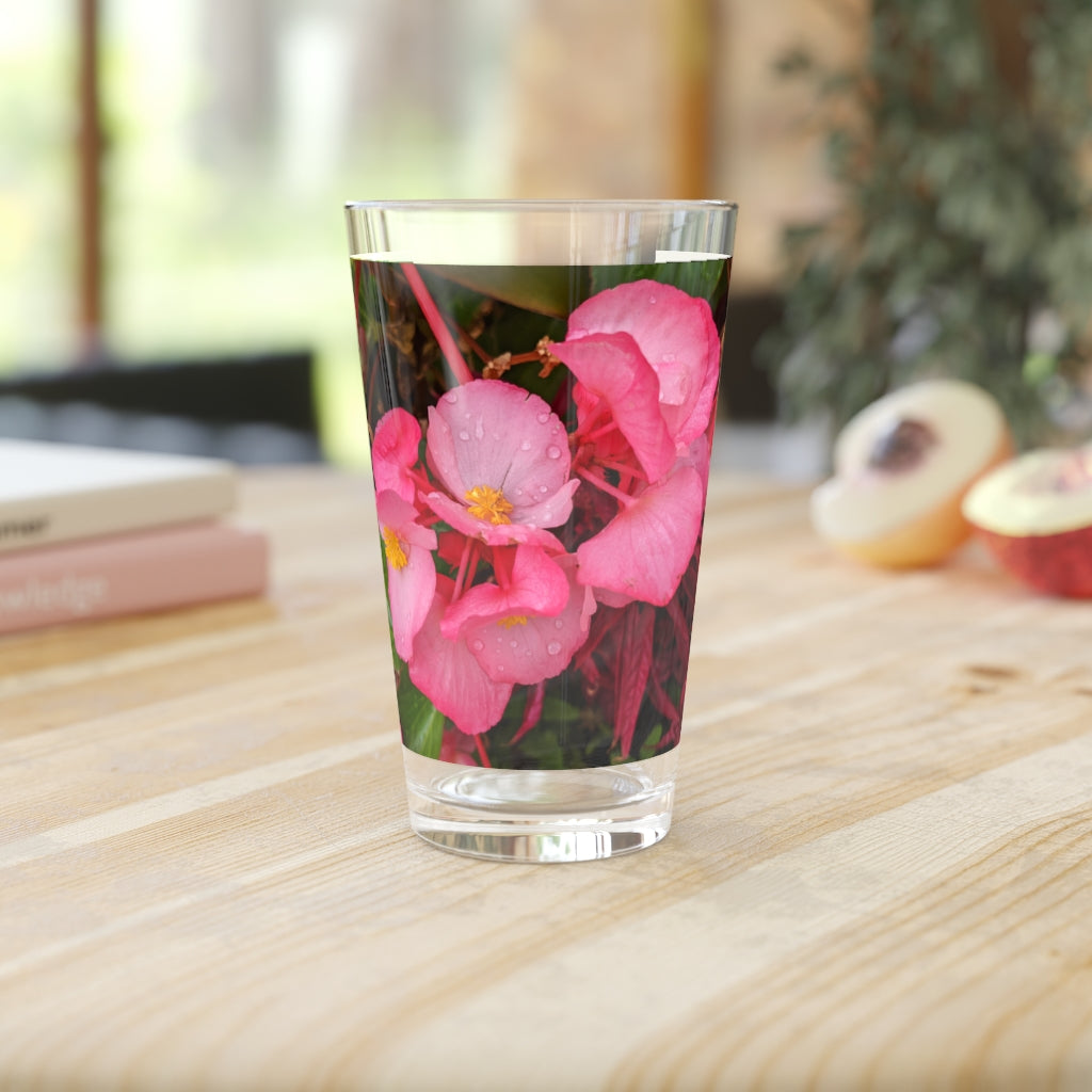 A clear 16oz pint glass featuring a pink flower design, perfect for personalized beverages.