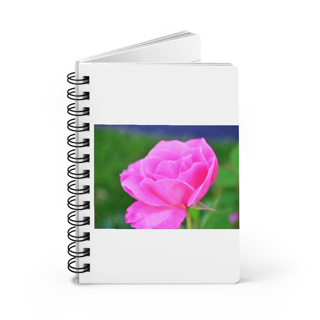 A stylish pink flower spiral bound journal with a glossy laminated cover, featuring vibrant floral designs and lined pages.