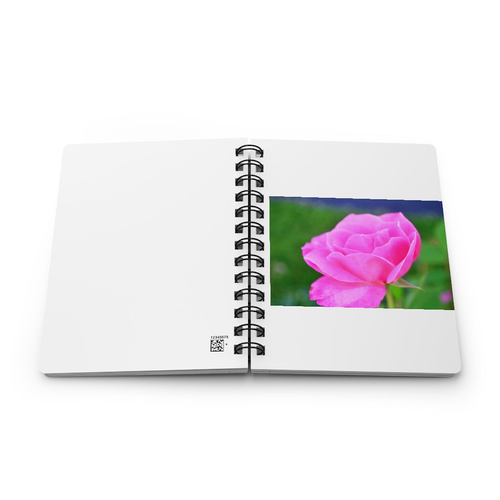 A stylish pink flower spiral bound journal with a glossy laminated cover, featuring vibrant floral designs and lined pages.