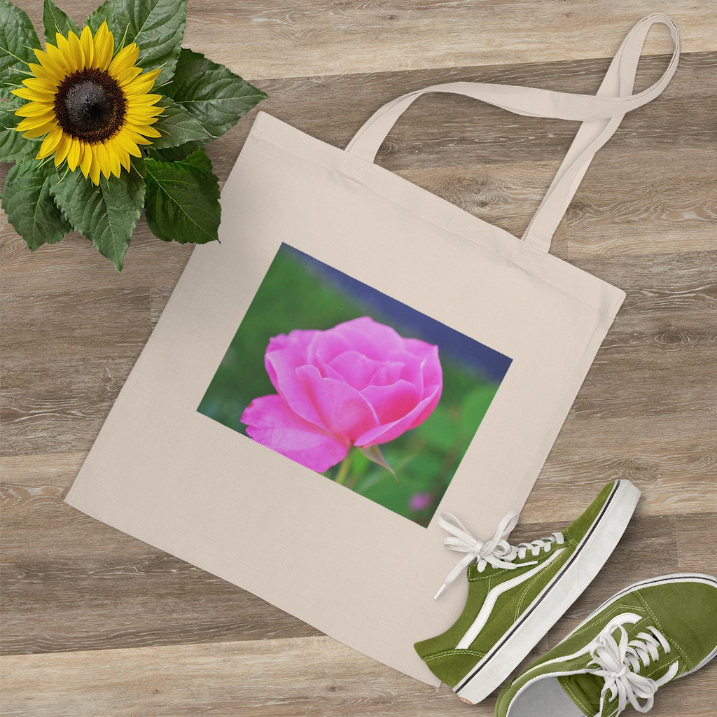 A stylish pink flower tote bag made of 100% cotton with long handles and cross stitching for added durability.