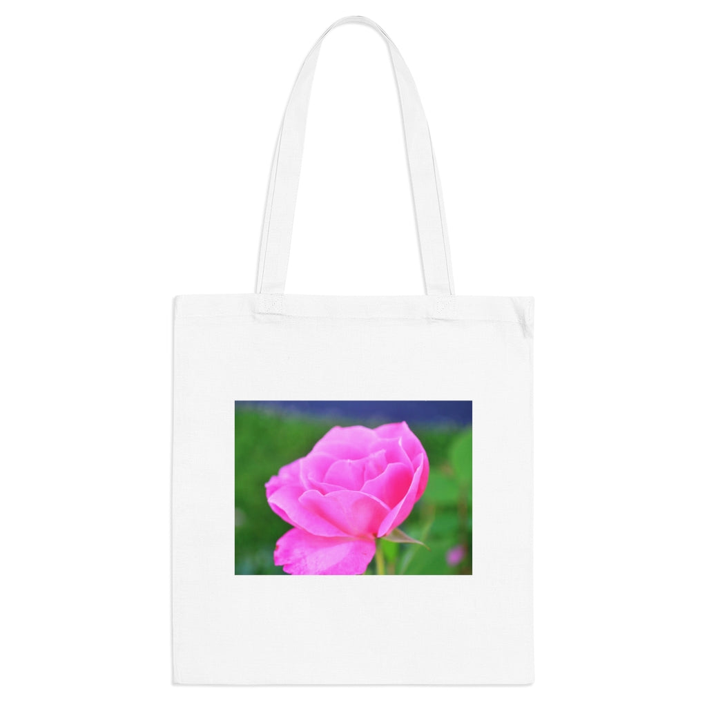 A stylish pink flower tote bag made of 100% cotton with long handles and cross stitching for added durability.