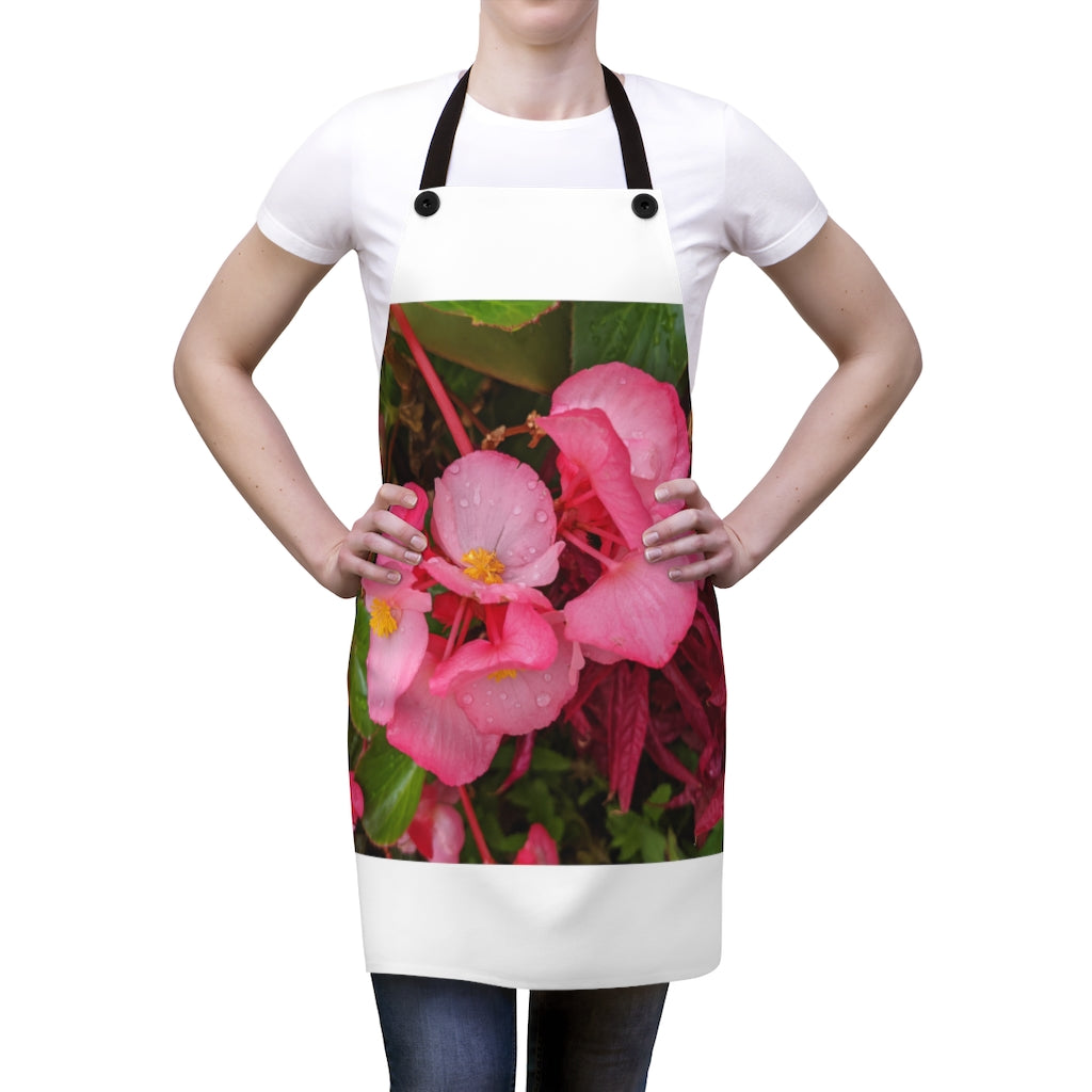 A stylish pink flowers apron with black detachable twill straps, perfect for cooking.