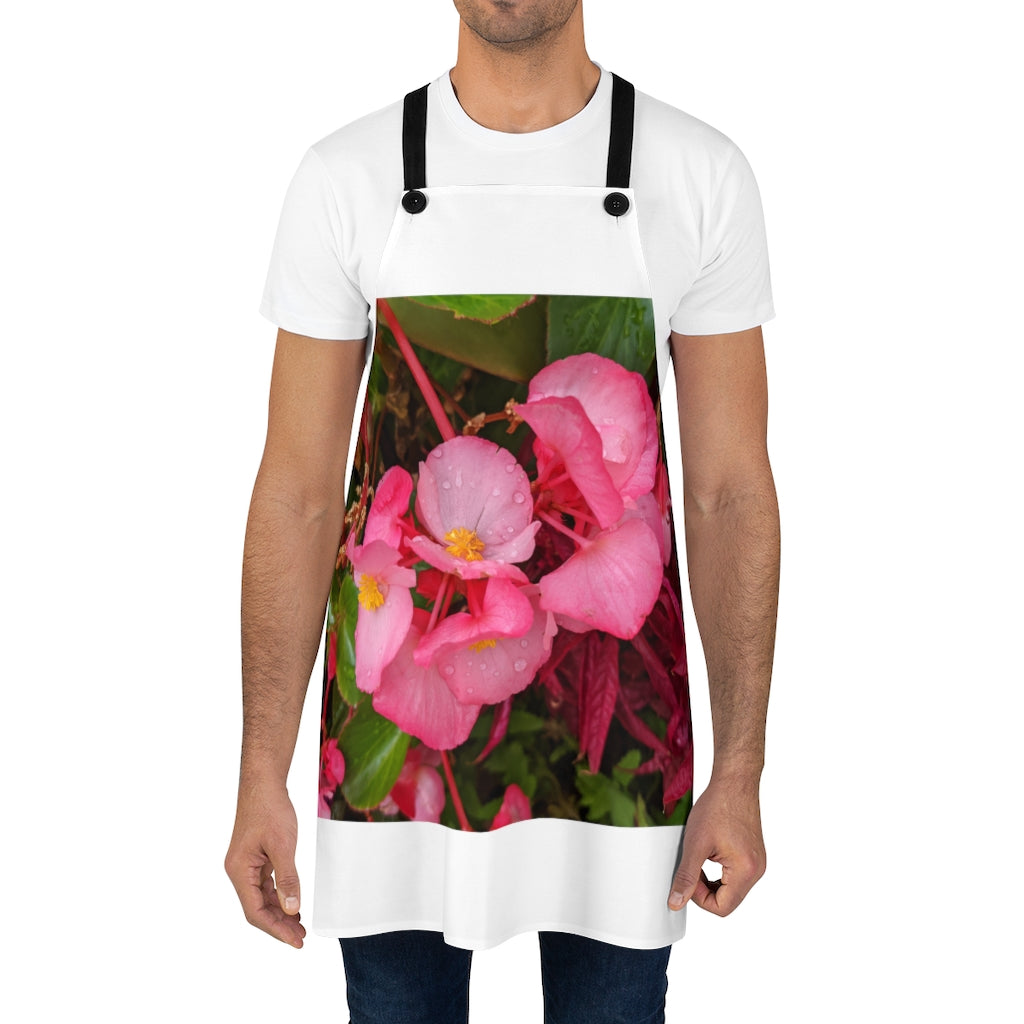 A stylish pink flowers apron with black detachable twill straps, perfect for cooking.