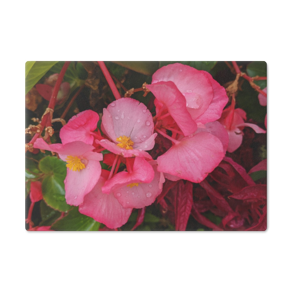 A stylish Pink Flowers Cutting Board made of tempered glass with a floral design and rubber dots for stability.