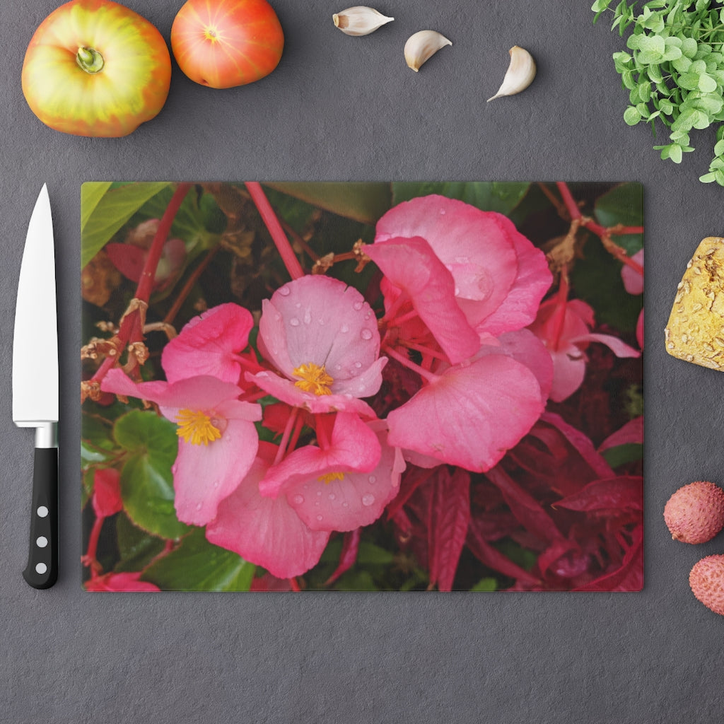 A stylish Pink Flowers Cutting Board made of tempered glass with a floral design and rubber dots for stability.