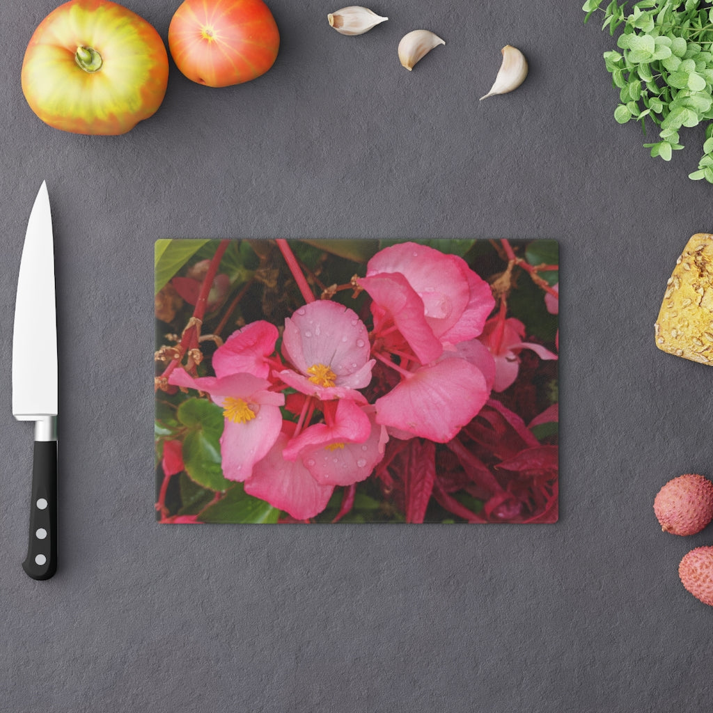 A stylish Pink Flowers Cutting Board made of tempered glass with a floral design and rubber dots for stability.