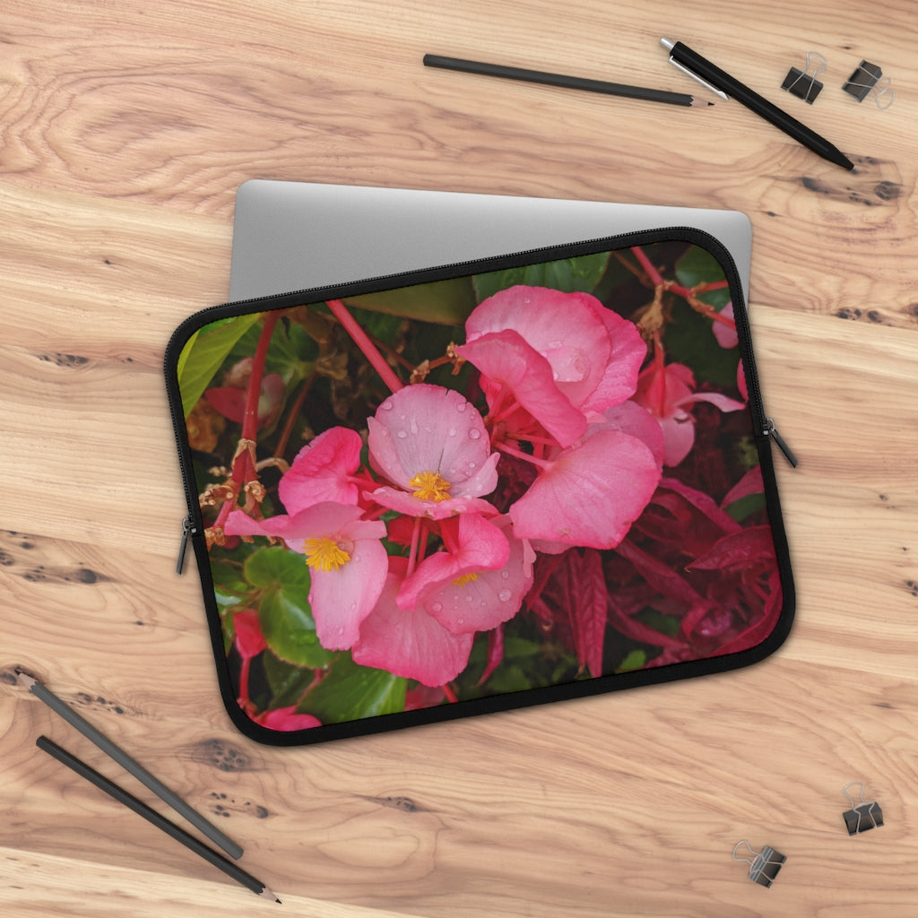 A stylish pink flowers laptop sleeve with a black polyester back, featuring dual zipper enclosures and a water-resistant design.