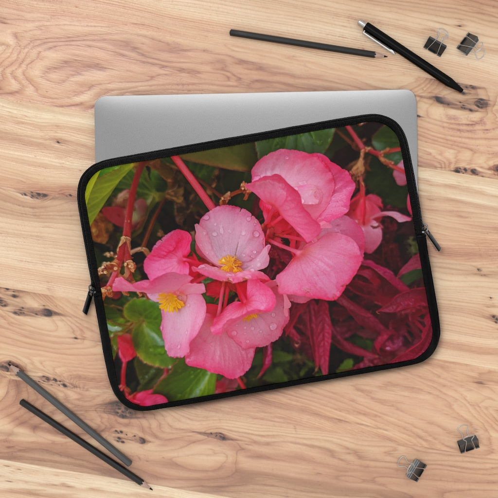 A stylish pink flowers laptop sleeve with a black polyester back, featuring dual zipper enclosures and a water-resistant design.