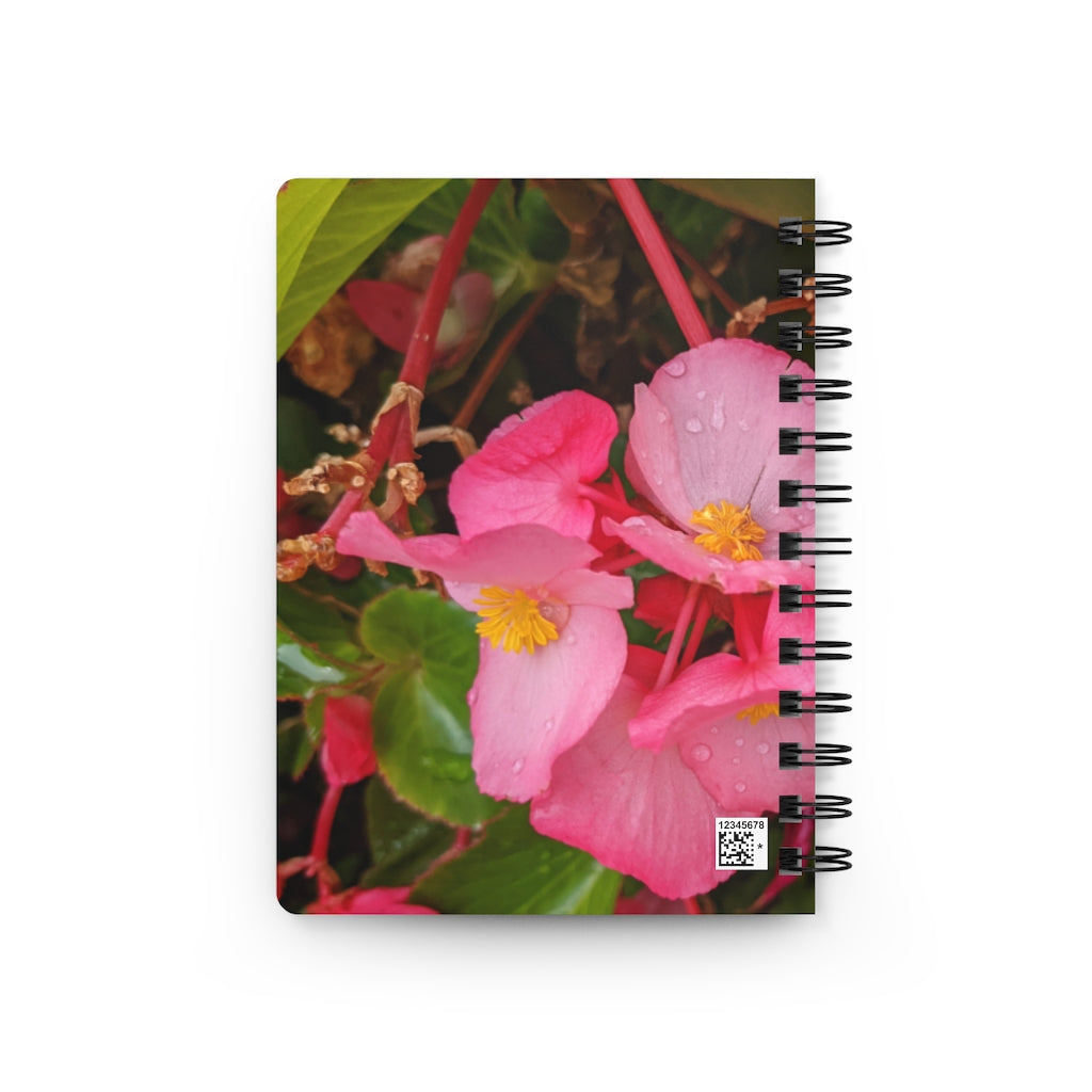 A vibrant pink flowers spiral bound journal with a glossy laminated cover, featuring lined pages for writing.