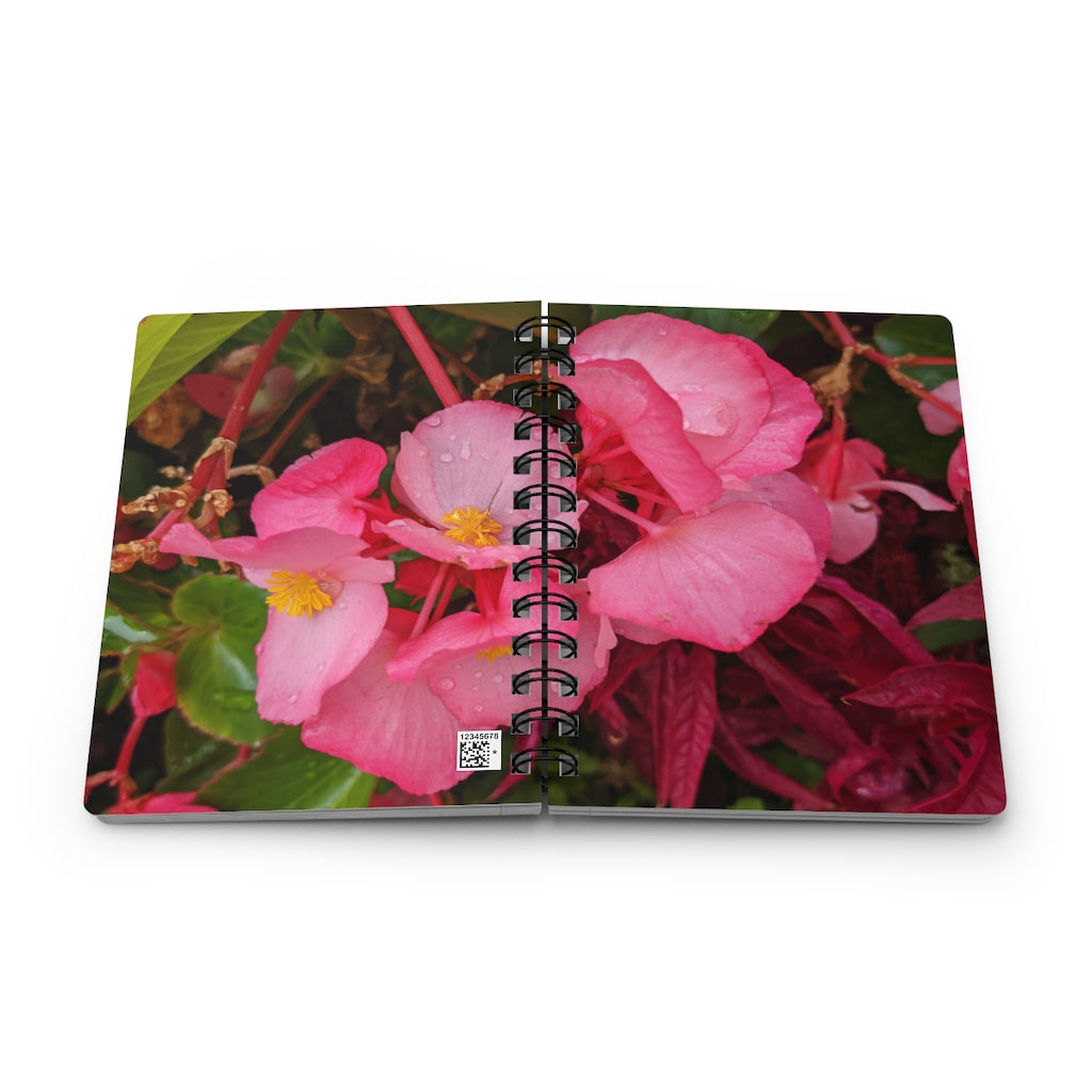 A vibrant pink flowers spiral bound journal with a glossy laminated cover, featuring lined pages for writing.