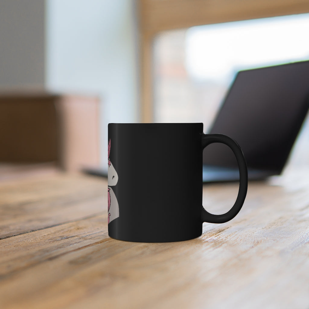 A stylish black ceramic mug featuring a vibrant pink unicorn design, perfect for coffee or tea.