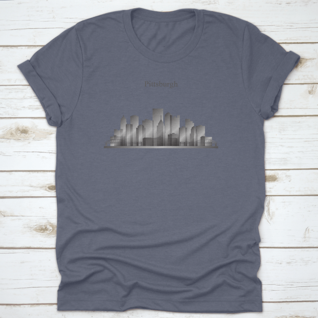 A grayscale shirt featuring the silhouette of Pittsburgh's city skyline, showcasing iconic buildings and structures.