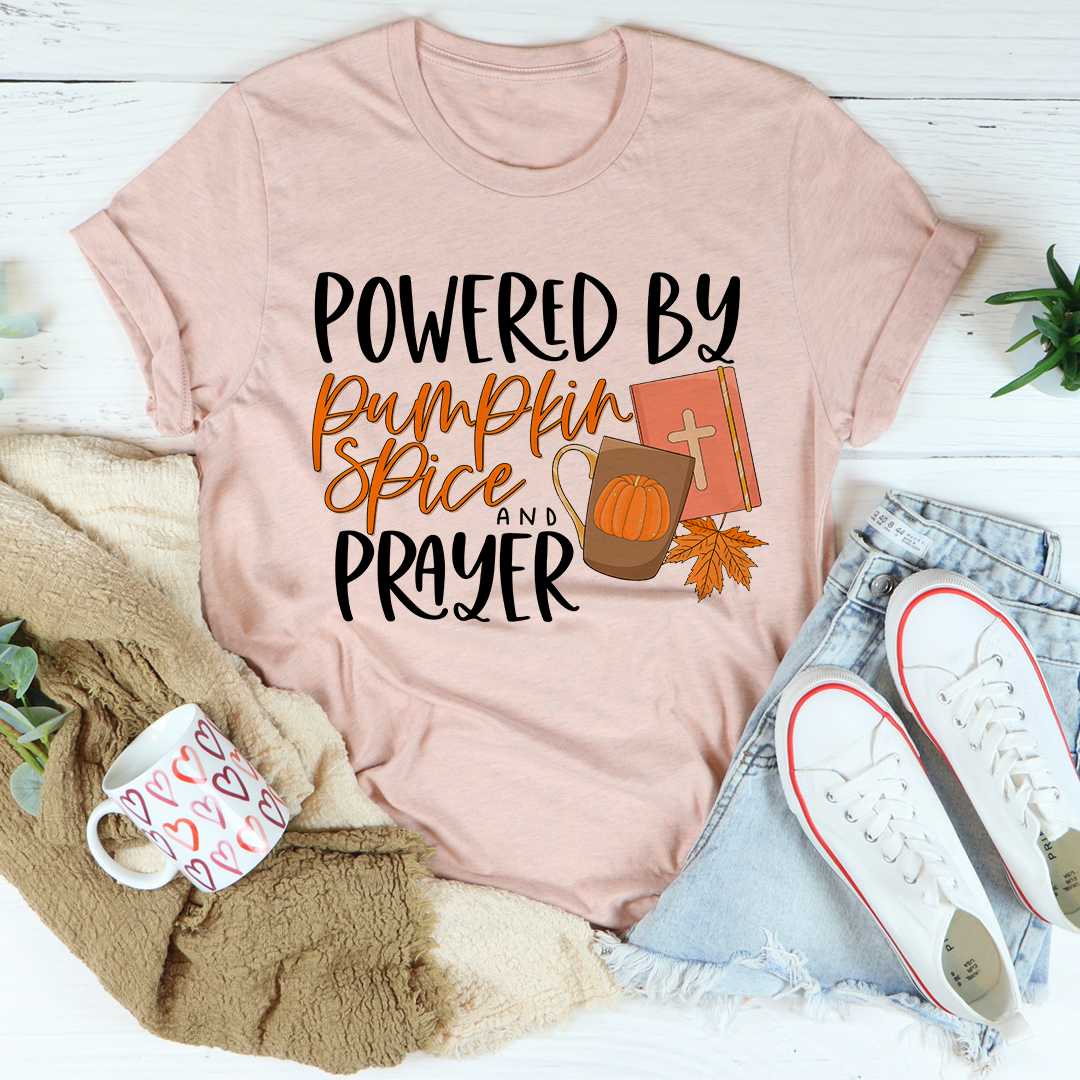 A cozy and stylish Powered By Pumpkin Spice & Prayer T-Shirt made from soft ring-spun cotton, featuring a trendy slogan.