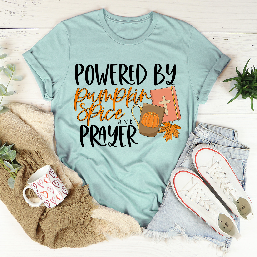 A cozy and stylish Powered By Pumpkin Spice & Prayer T-Shirt made from soft ring-spun cotton, featuring a trendy slogan.