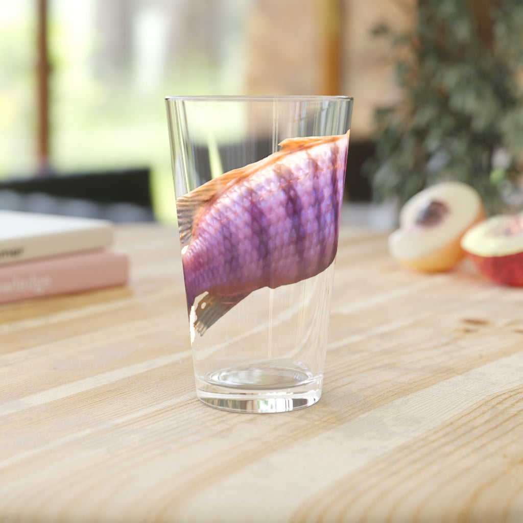 A clear 16oz pint glass featuring a purple fish design, perfect for personalized drinks.