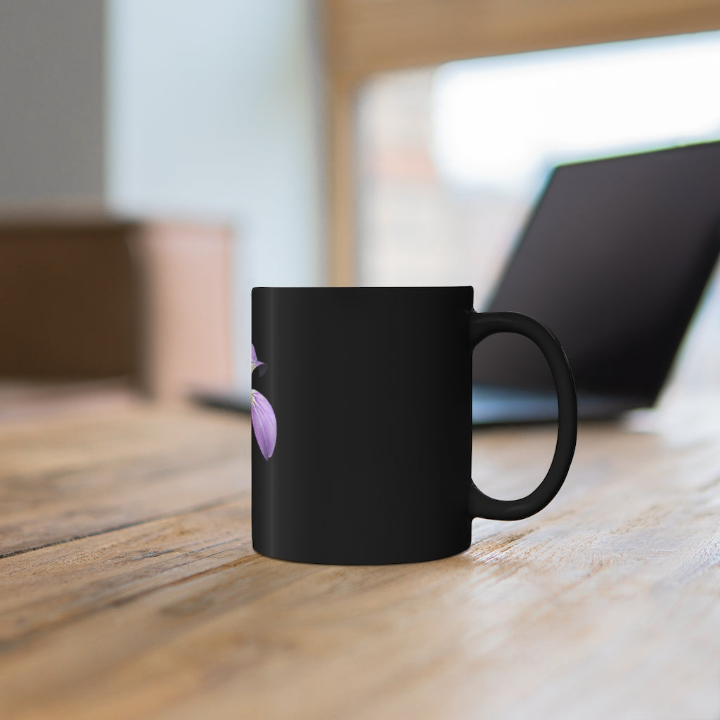 A stylish 11oz black ceramic mug featuring a vibrant purple flower design, perfect for coffee or tea.