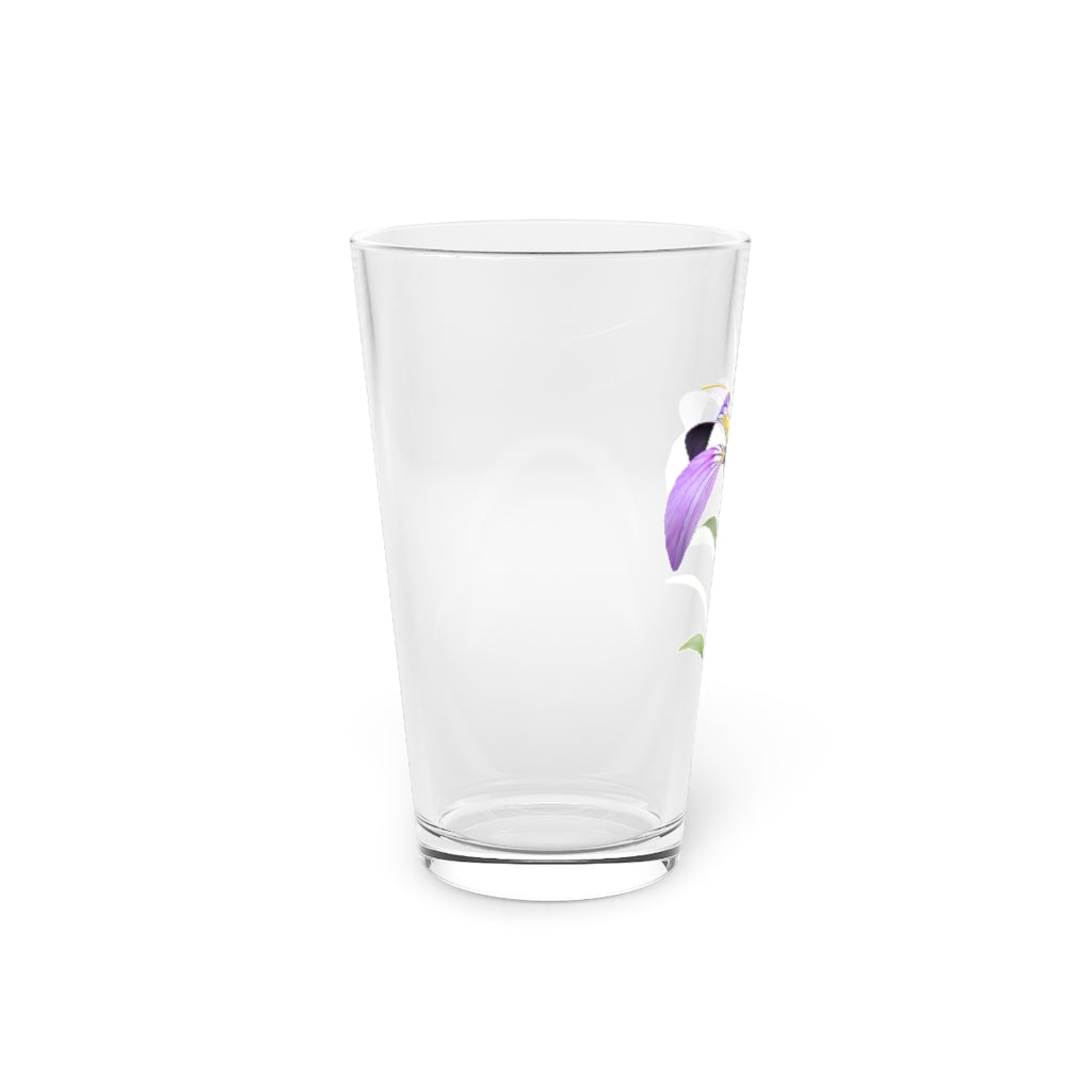 A clear 16oz pint glass featuring a beautiful purple flower design, perfect for beverages.