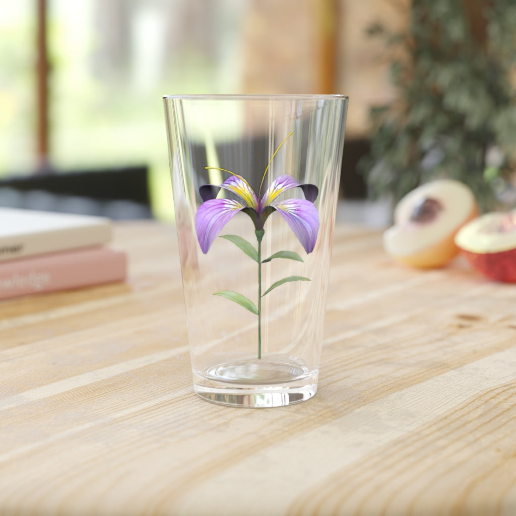 A clear 16oz pint glass featuring a beautiful purple flower design, perfect for beverages.