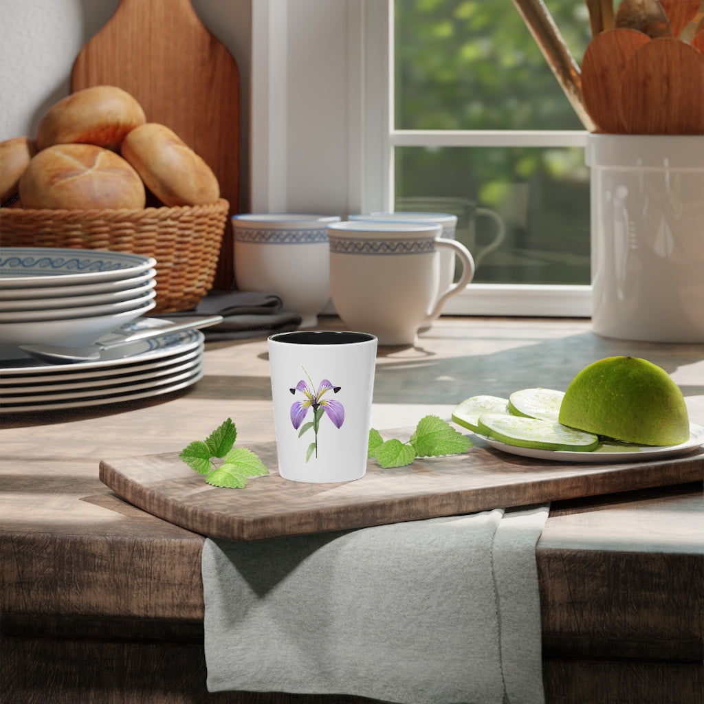 A personalized Purple Flower Shot Glass with a ceramic finish, featuring a vibrant purple floral design and available with a white or black interior.