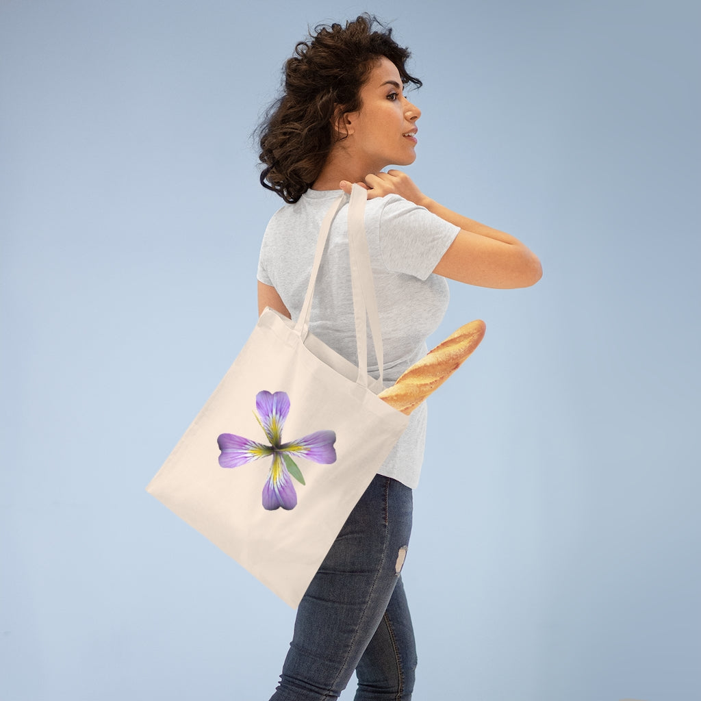 A stylish purple flower tote bag made of 100% cotton with long handles and cross stitching for added durability.