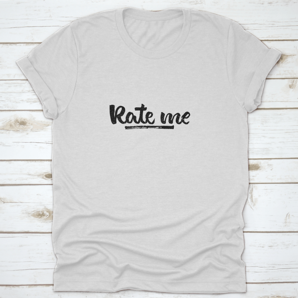 A stylish t-shirt featuring modern brush calligraphy design with the words 'Rate Me. Ink Hand Lettering' on a soft cotton fabric.