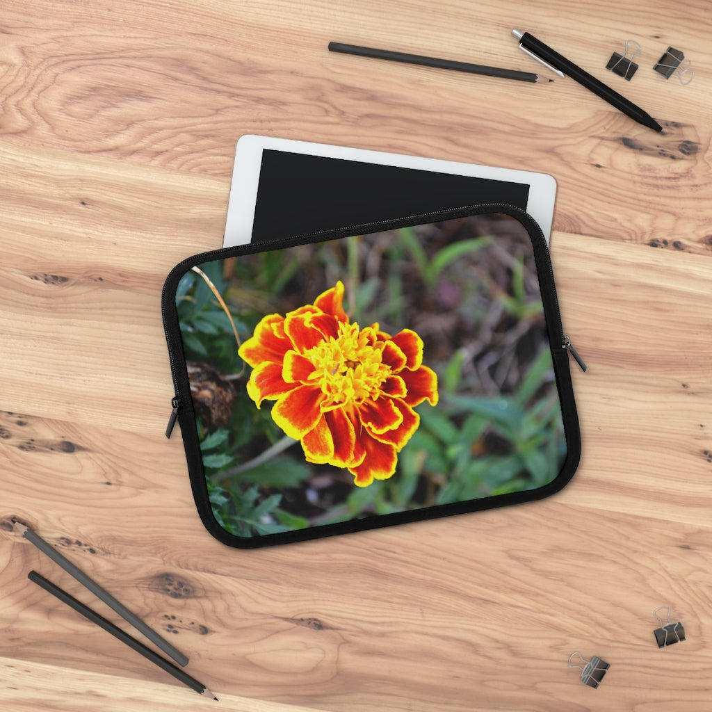 A vibrant red and yellow flower laptop sleeve with a black polyester back, featuring dual zipper enclosures and a smooth neoprene material.