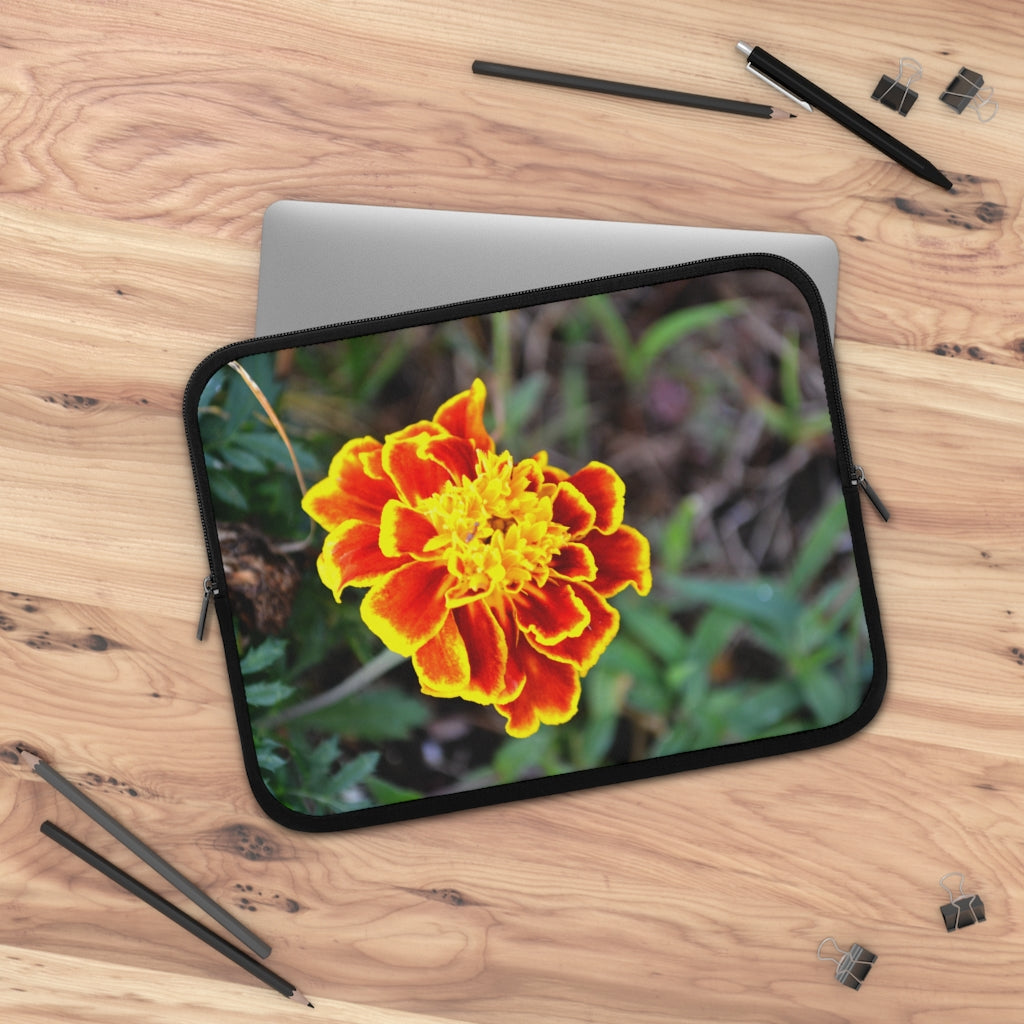 A vibrant red and yellow flower laptop sleeve with a black polyester back, featuring dual zipper enclosures and a smooth neoprene material.