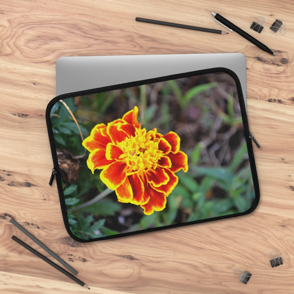 A vibrant red and yellow flower laptop sleeve with a black polyester back, featuring dual zipper enclosures and a smooth neoprene material.