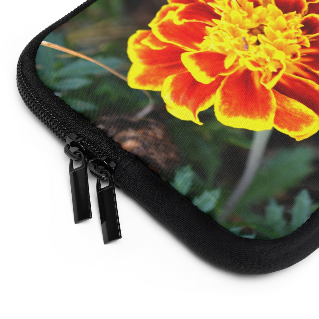 A vibrant red and yellow flower laptop sleeve with a black polyester back, featuring dual zipper enclosures and a smooth neoprene material.