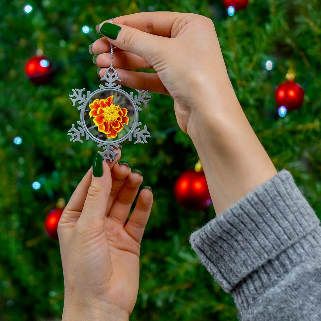 A beautifully crafted Red and Yellow Flower Pewter Snowflake Ornament with a silver-toned hanging string, showcasing vibrant colors.