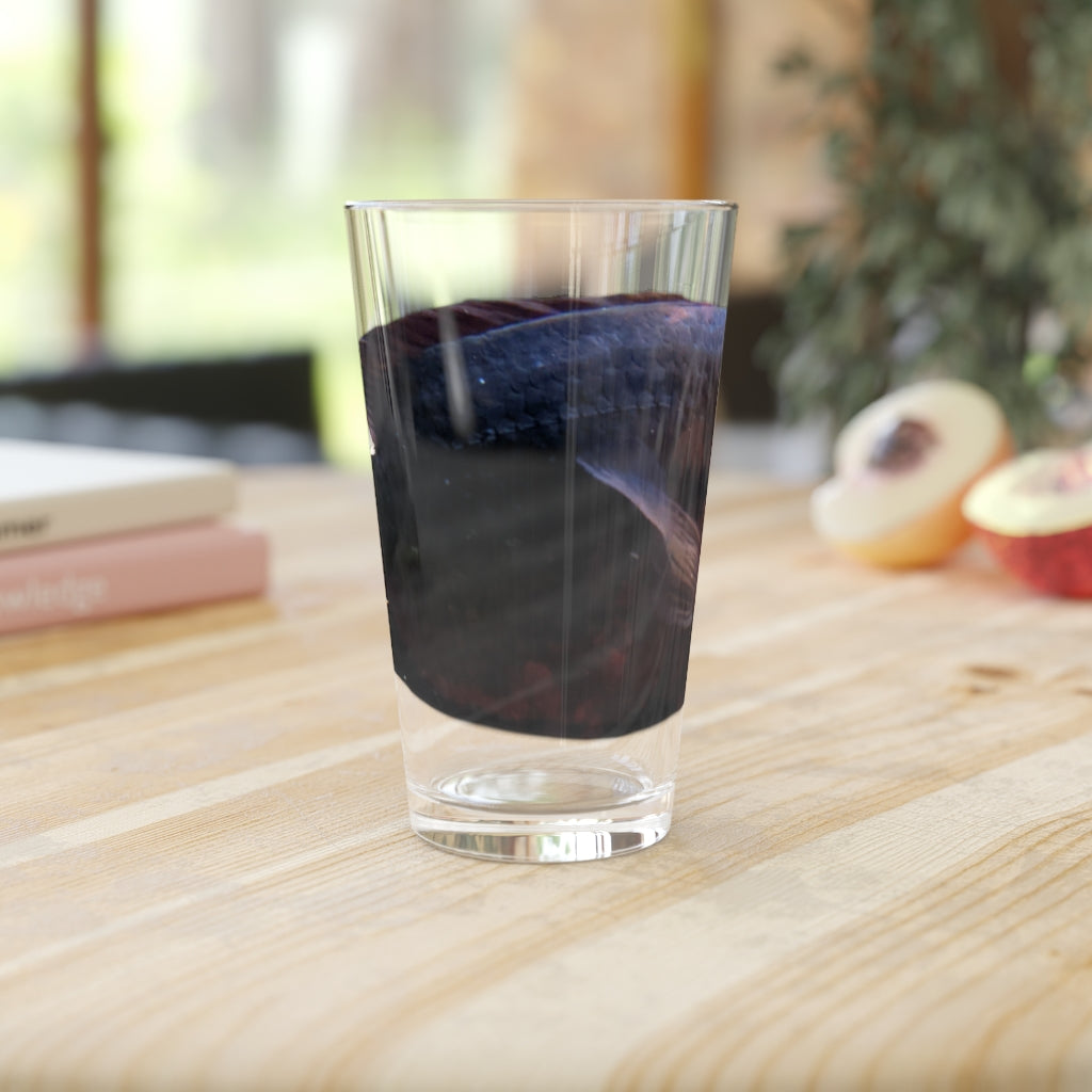 A clear 16oz pint glass featuring a red and black fish design, perfect for personalized beverages.