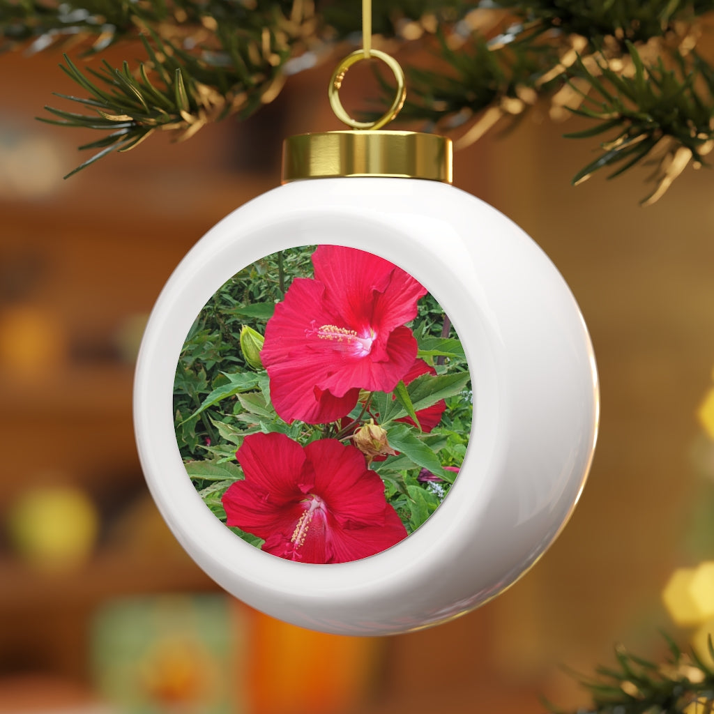 A vibrant red Christmas ball ornament featuring floral designs, glossy finish, and a gold ribbon for hanging, perfect for holiday decor.