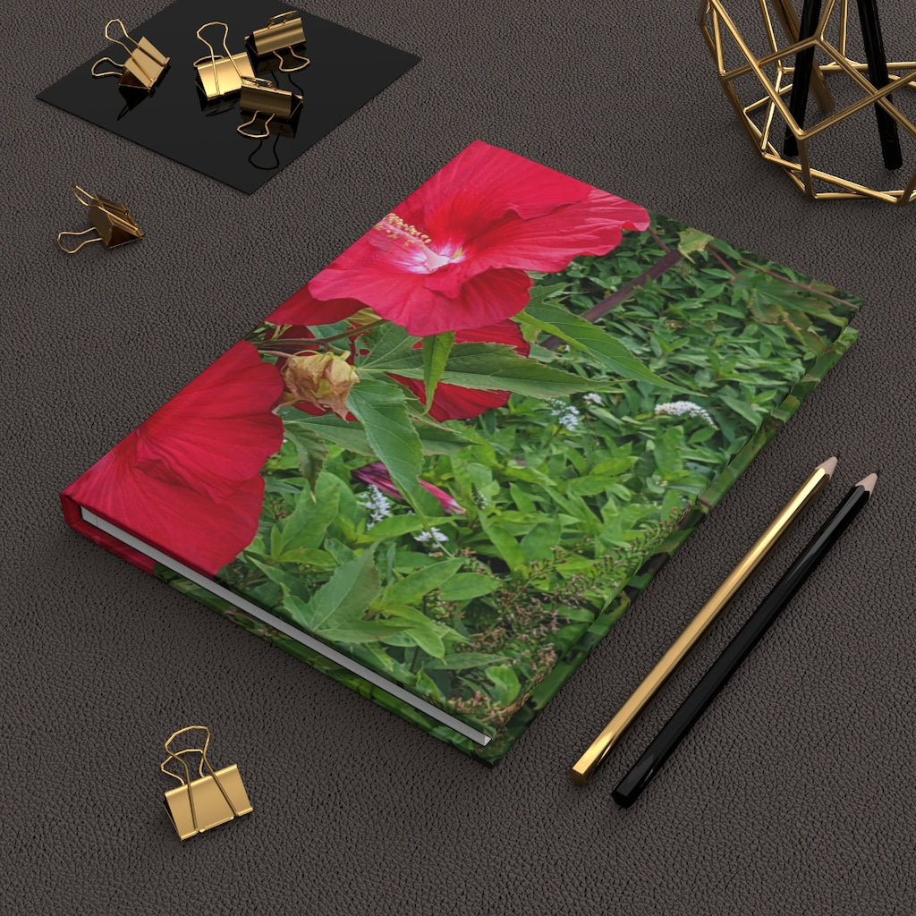 A beautifully designed Red Flowers Hardcover Journal with a matte finish, featuring vibrant floral patterns on the cover.