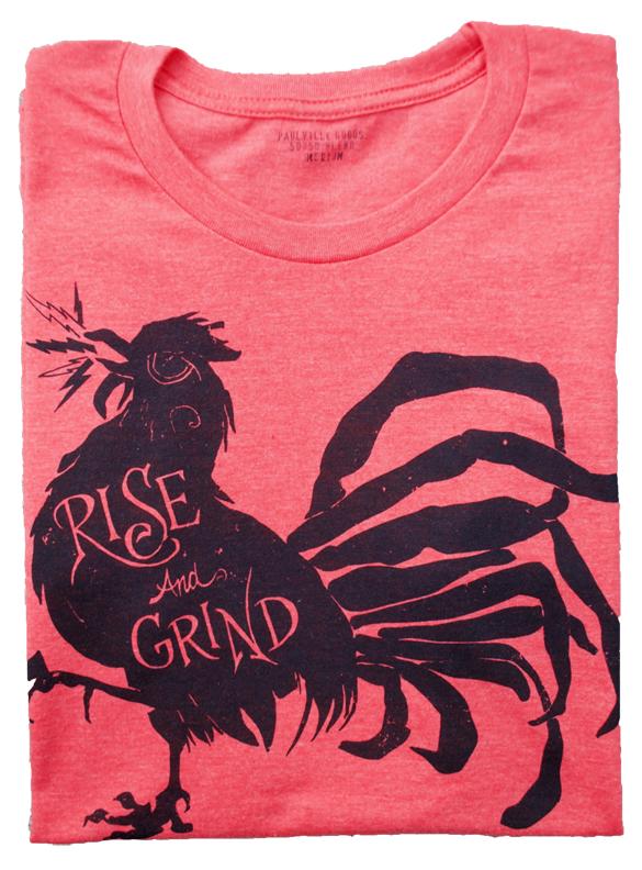 Rise and Grind Heather Red T-shirt displayed on a wooden surface, showcasing its soft fabric and vibrant color.