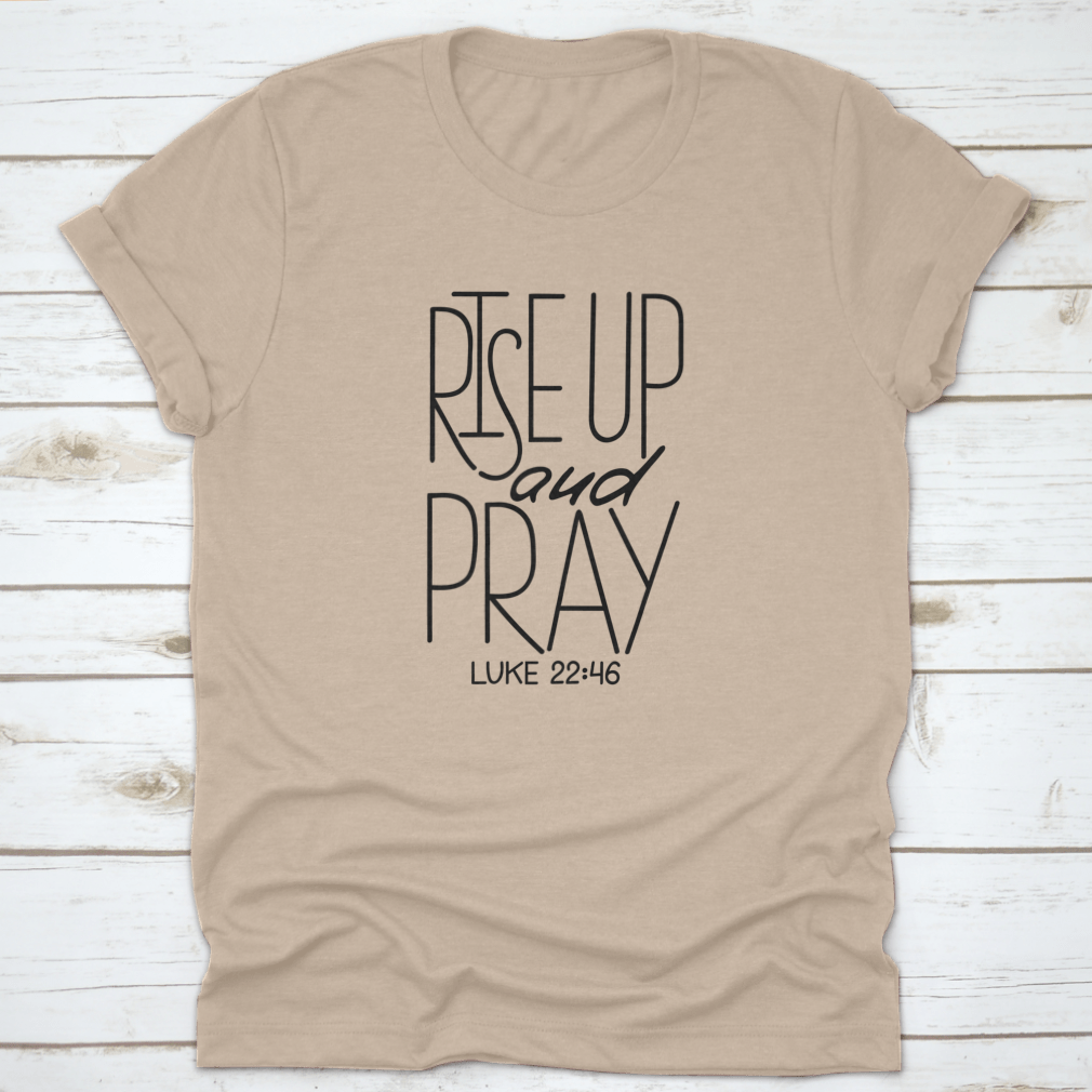 Rise Up And Pray T-Shirt featuring an inspirational quote design, made from soft cotton fabric, displayed on a neutral background.