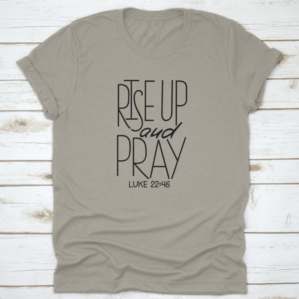 Rise Up And Pray T-Shirt featuring an inspirational quote design, made from soft cotton fabric, displayed on a neutral background.