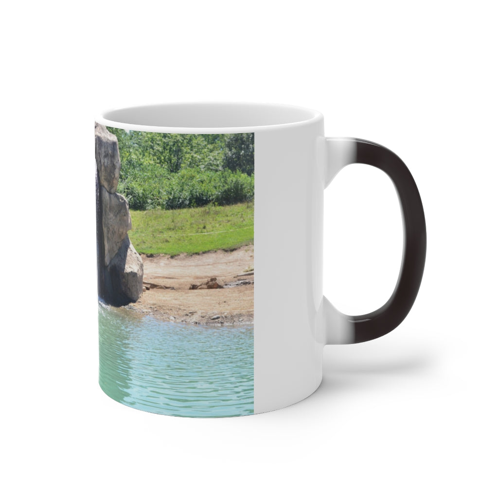 A white ceramic mug featuring a rock waterfall design that changes color when filled with hot liquid, available in 11oz and 15oz sizes.